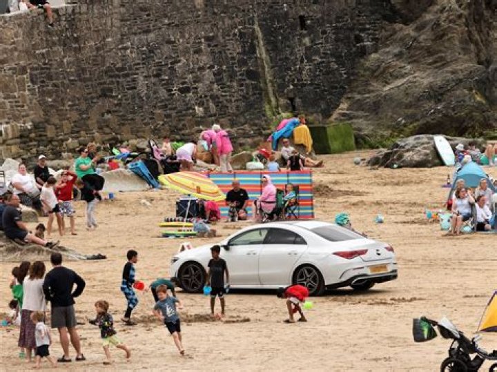 Mercedes driver blasted after brazenly parking on packed beach - infuriating locals