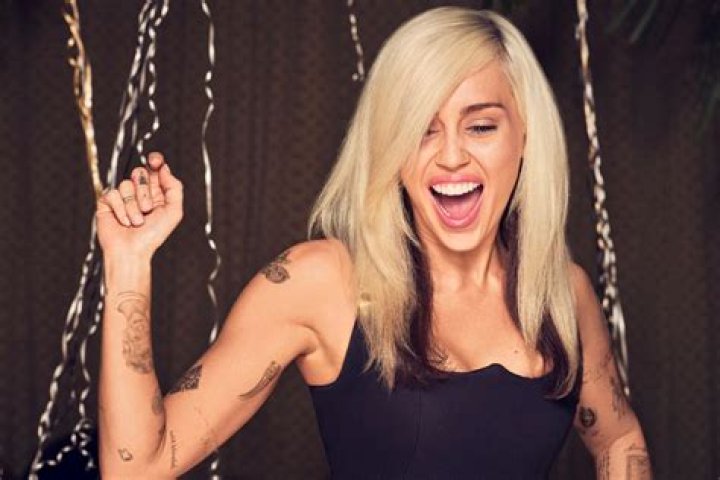 Miley Cyrus shows off collection of 50 tattoos including dogs, skeletons and one on her lip – The Sun