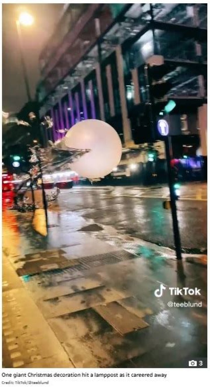 Moment giant Christmas baubles the size of a bus roll down West End street after high winds blow them down