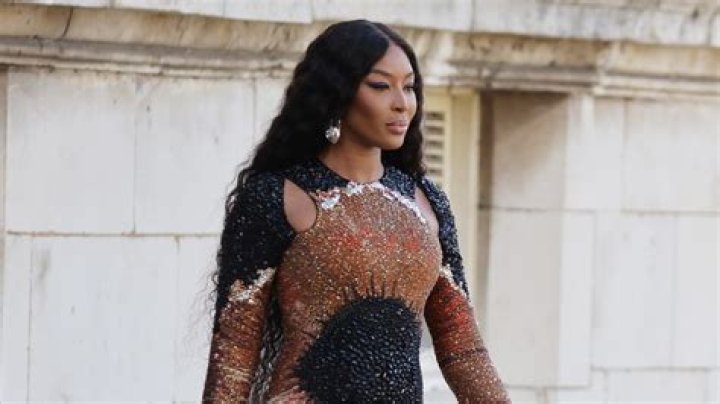 Naomi Campbell, 52, stuns in a cut-away sparkly jumpsuit and boots at fashion show