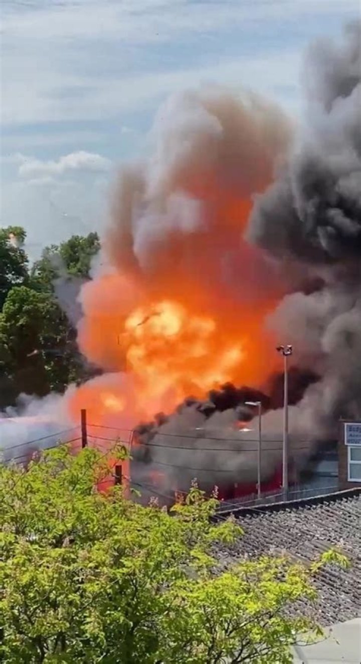 Shocking moment bus EXPLODES during massive blaze at garage as firefighters battle to put it out