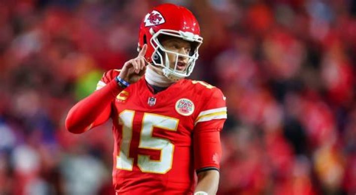 Why does Patrick Mahomes wear his helmet so high and wiggle his fingers between plays?